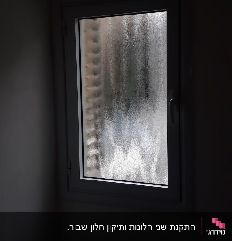 חלון עם תריסים מטושטשים מאחוריו